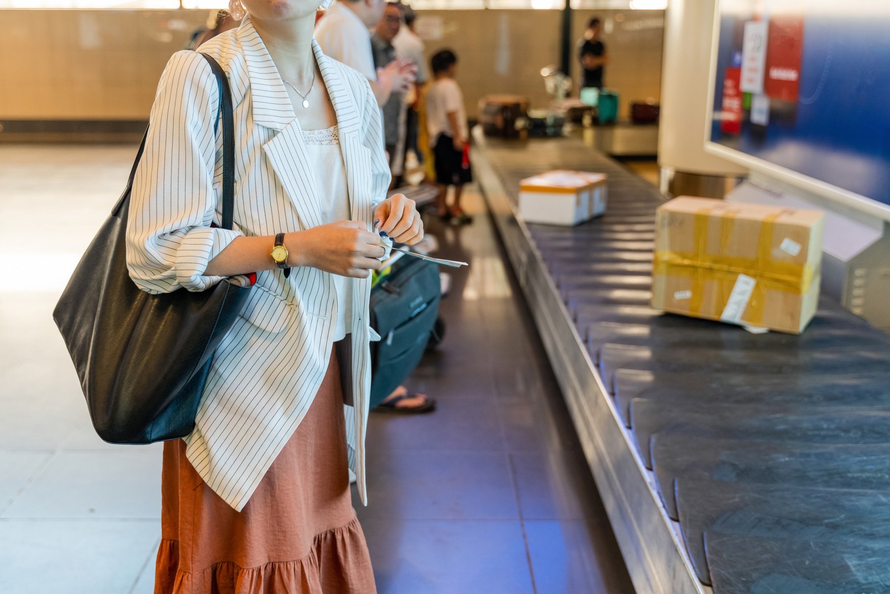 Woman Waiting for Her Luggage at the Baggage Claim